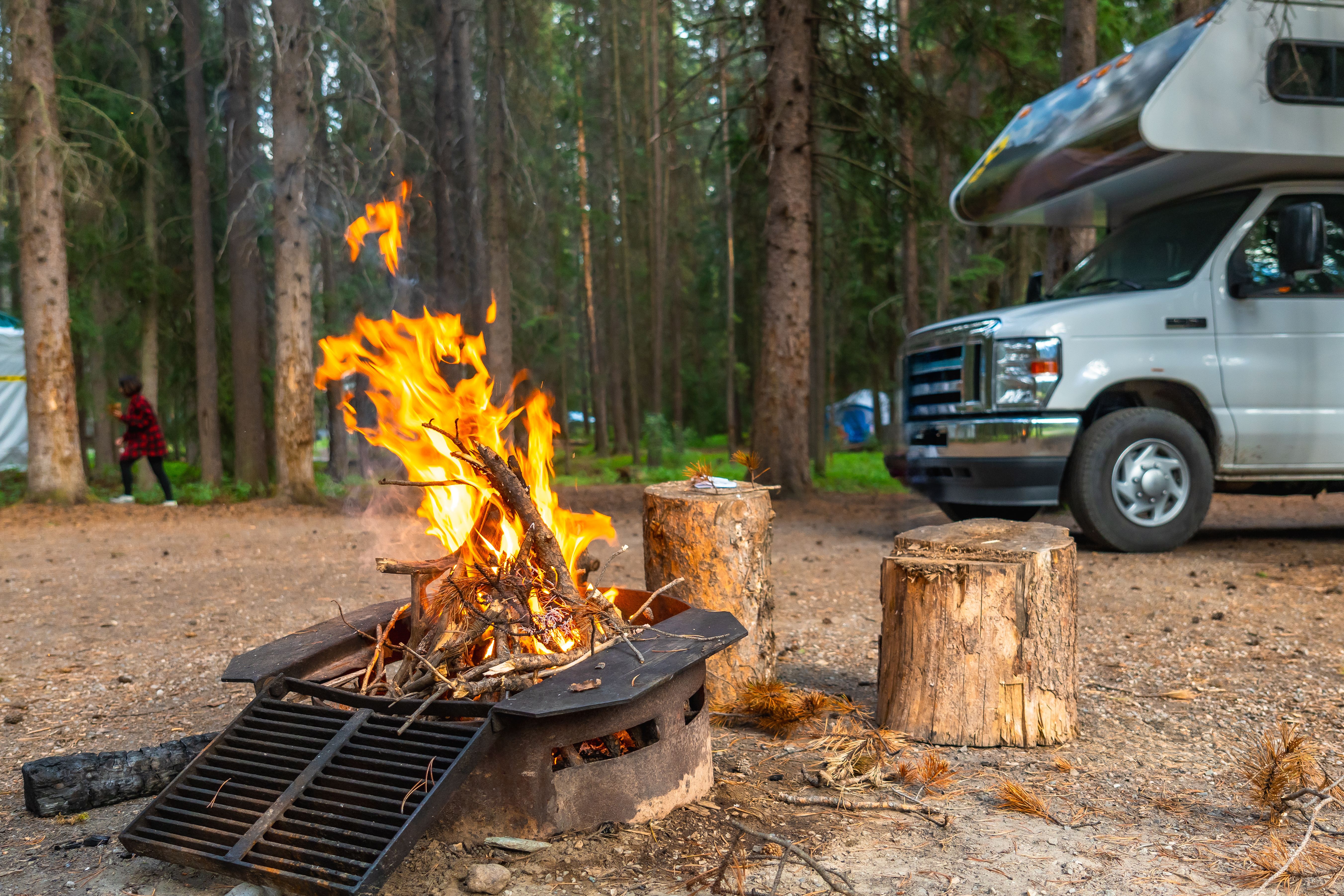 campfire-burning-brightly-next-to-rv-in-campsite